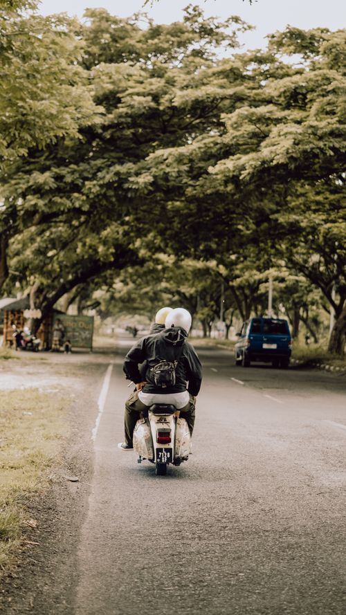 Free Two riders on a scooter enjoying a scenic road in East Java, Indonesia. Stock Photo