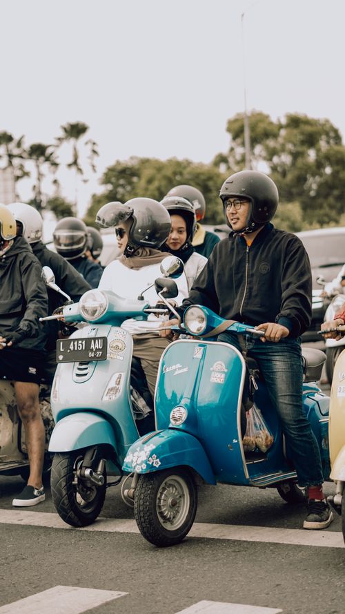 Free A joyful group of young adults riding classic scooters in East Java, Indonesia, showcasing community spirit and adventure. Stock Photo