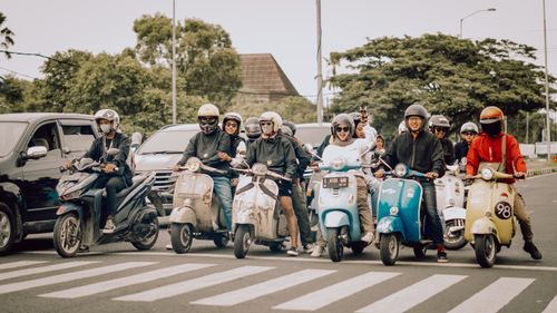 Free A lively group of scooter riders waiting at a crosswalk in East Java, Indonesia. Stock Photo