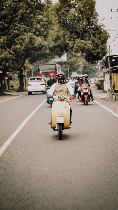 Free A group of people riding Vespas down a scenic road in East Java, Indonesia. Stock Photo