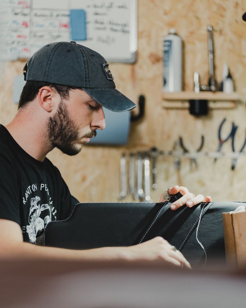 Craftsman hand-stitching upholstery fabric in a workshop