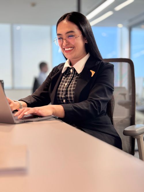 Free Confident businesswoman using a laptop at modern office desk, smiling. Stock Photo