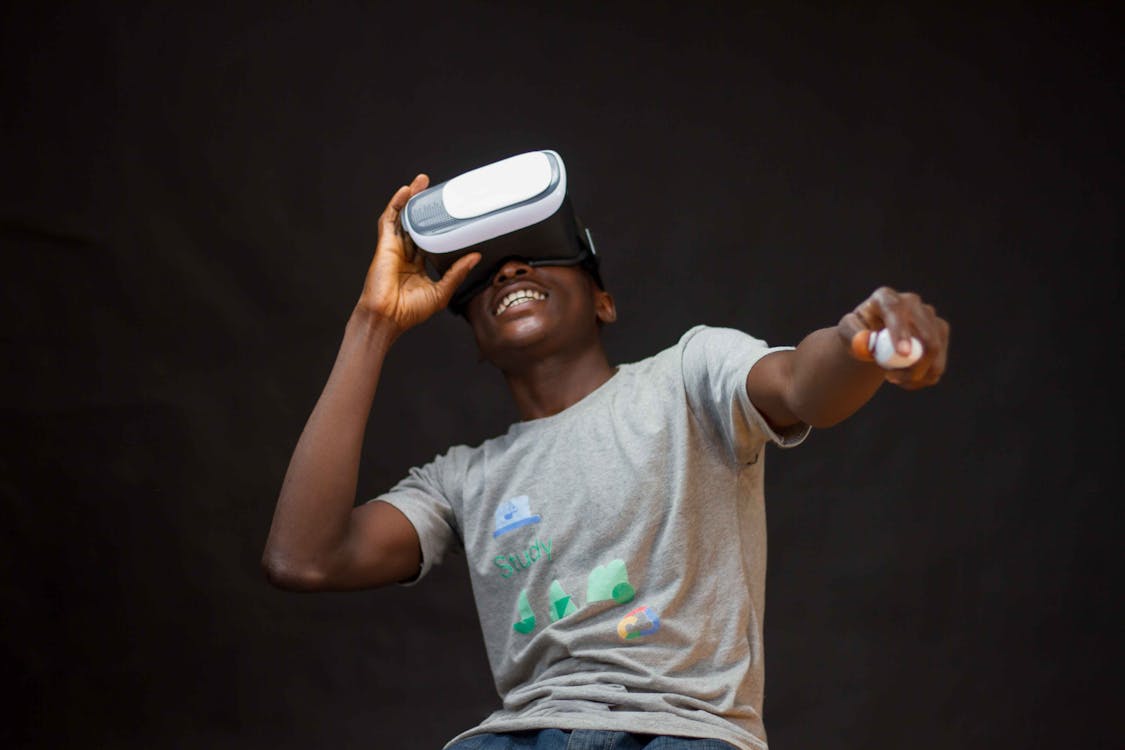 Man Wearing Grey Shirt Using Virtual Realty Headset