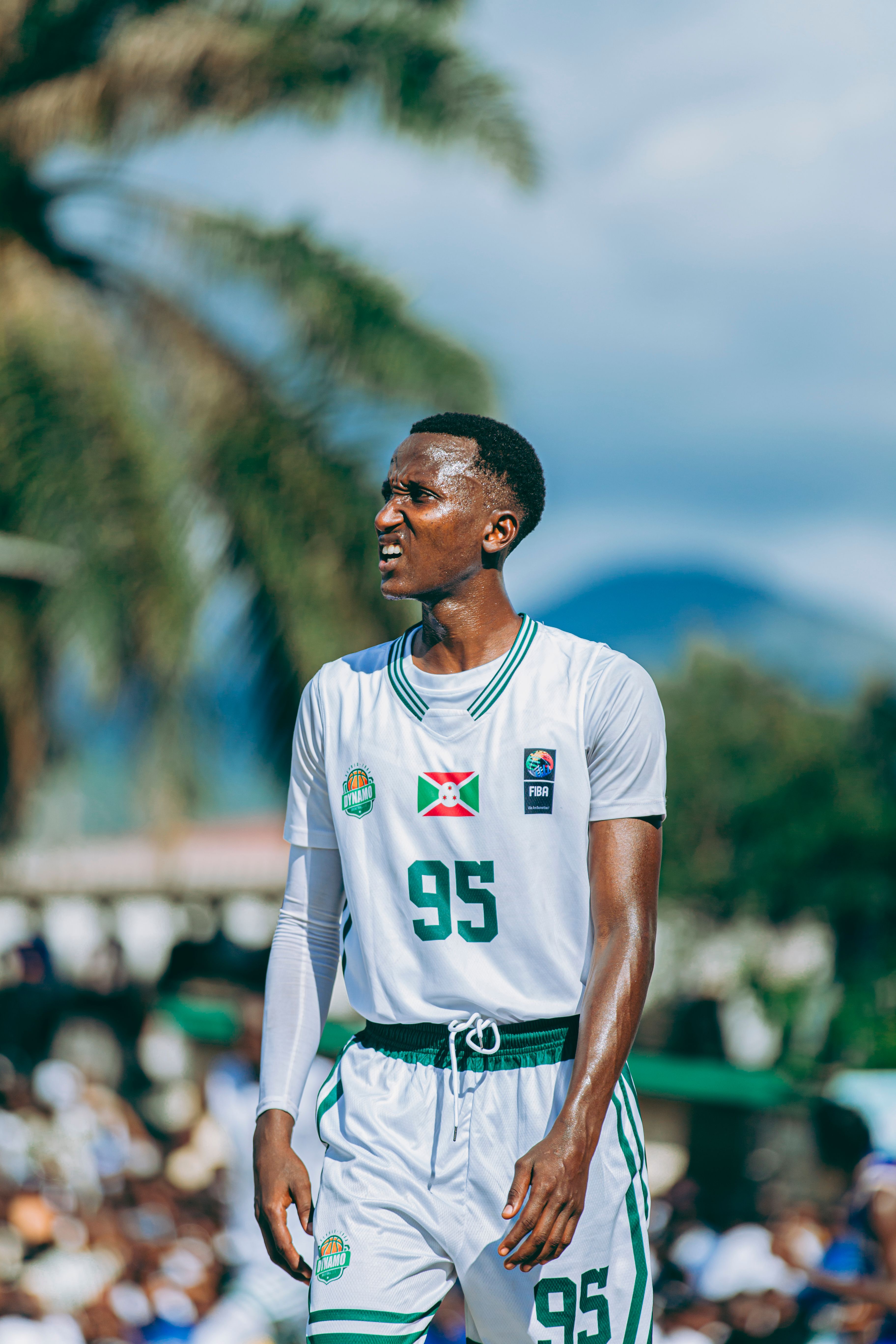 Young athlete performs energetically in an outdoor basketball game, showcasing skill and intensity.