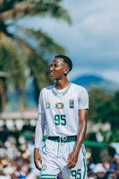 Young athlete performs energetically in an outdoor basketball game, showcasing skill and intensity.