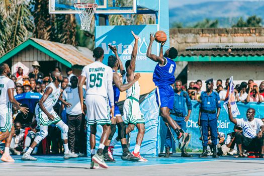 Basketball players in action during an outdoor game, showcasing athletic skill and teamwork.