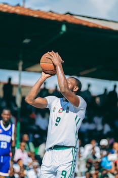 Basketball player makes shot outdoors during intense game