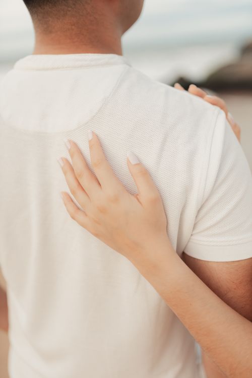 Free Close-up of a couple embracing on the beach, highlighting connection and romance. Stock Photo