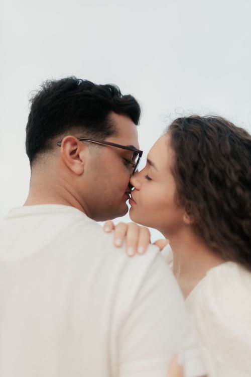 Free A young couple shares an intimate and loving moment with a kiss outdoors. Stock Photo