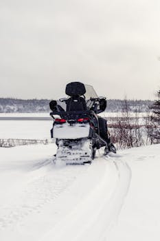Snowmobile parked in snowy Chevery, Québec landscape during wintertime.