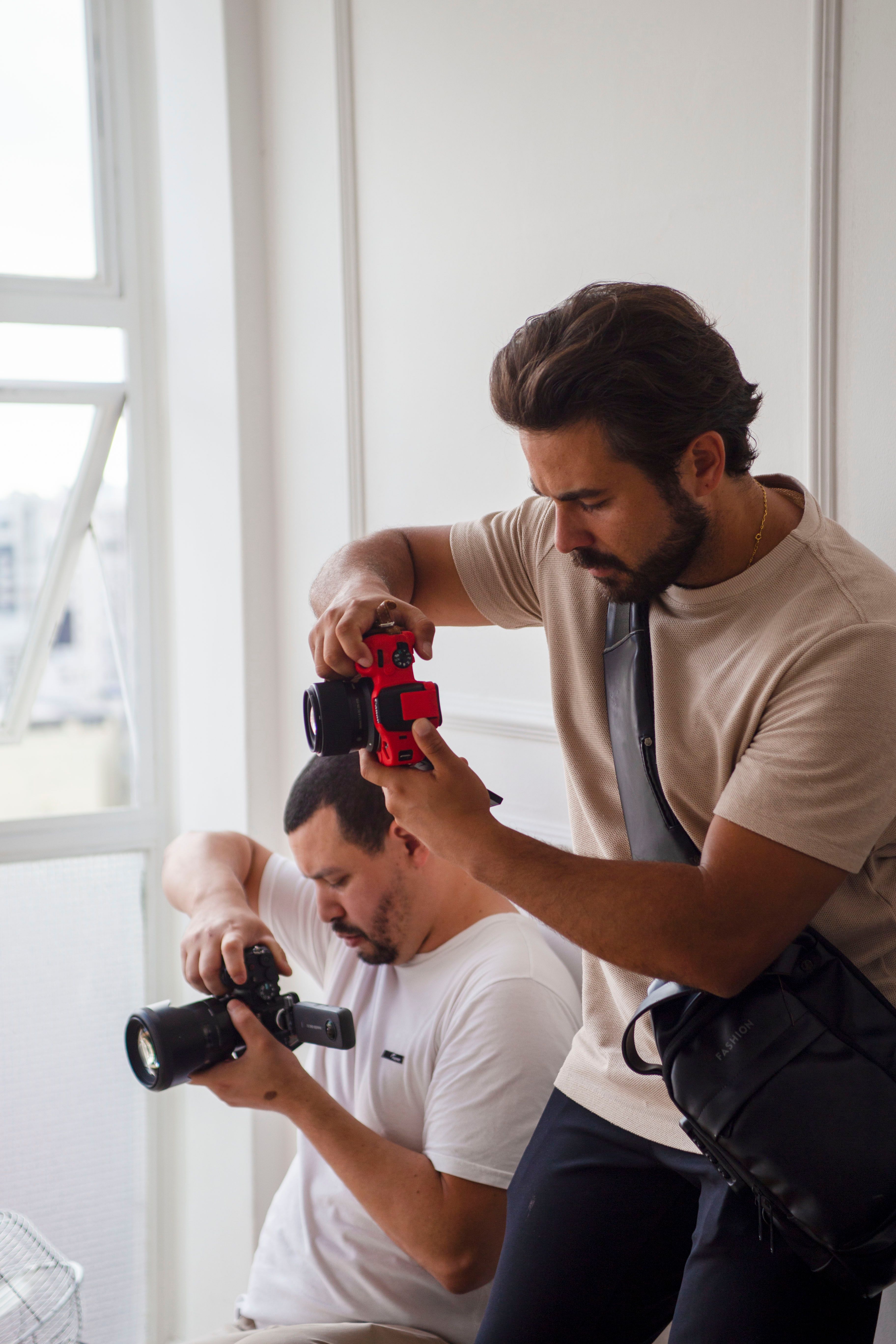 Two photographers working indoors capturing creative shots in a studio.