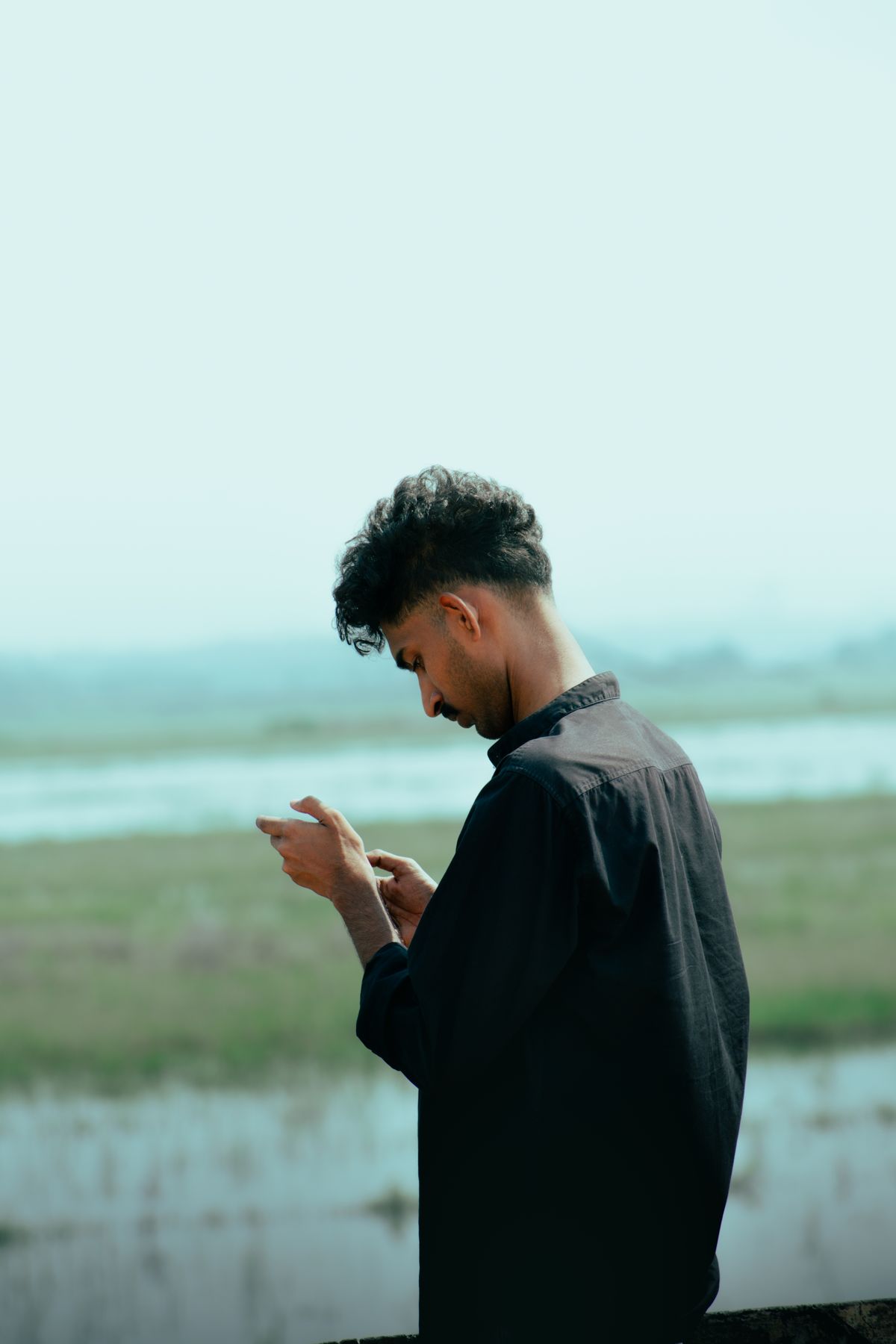Person outdoors holding a smartphone in a natural setting