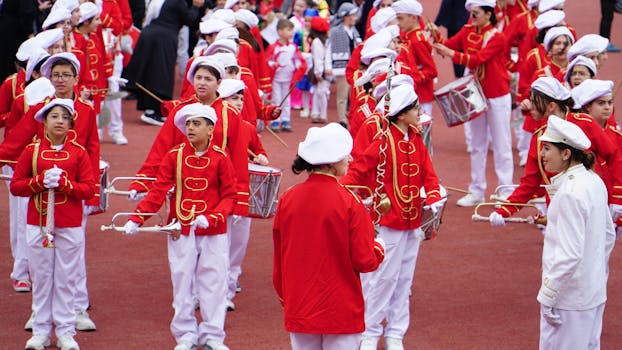 Children in colorful uniforms playing instruments during a celebration in Istanbul.