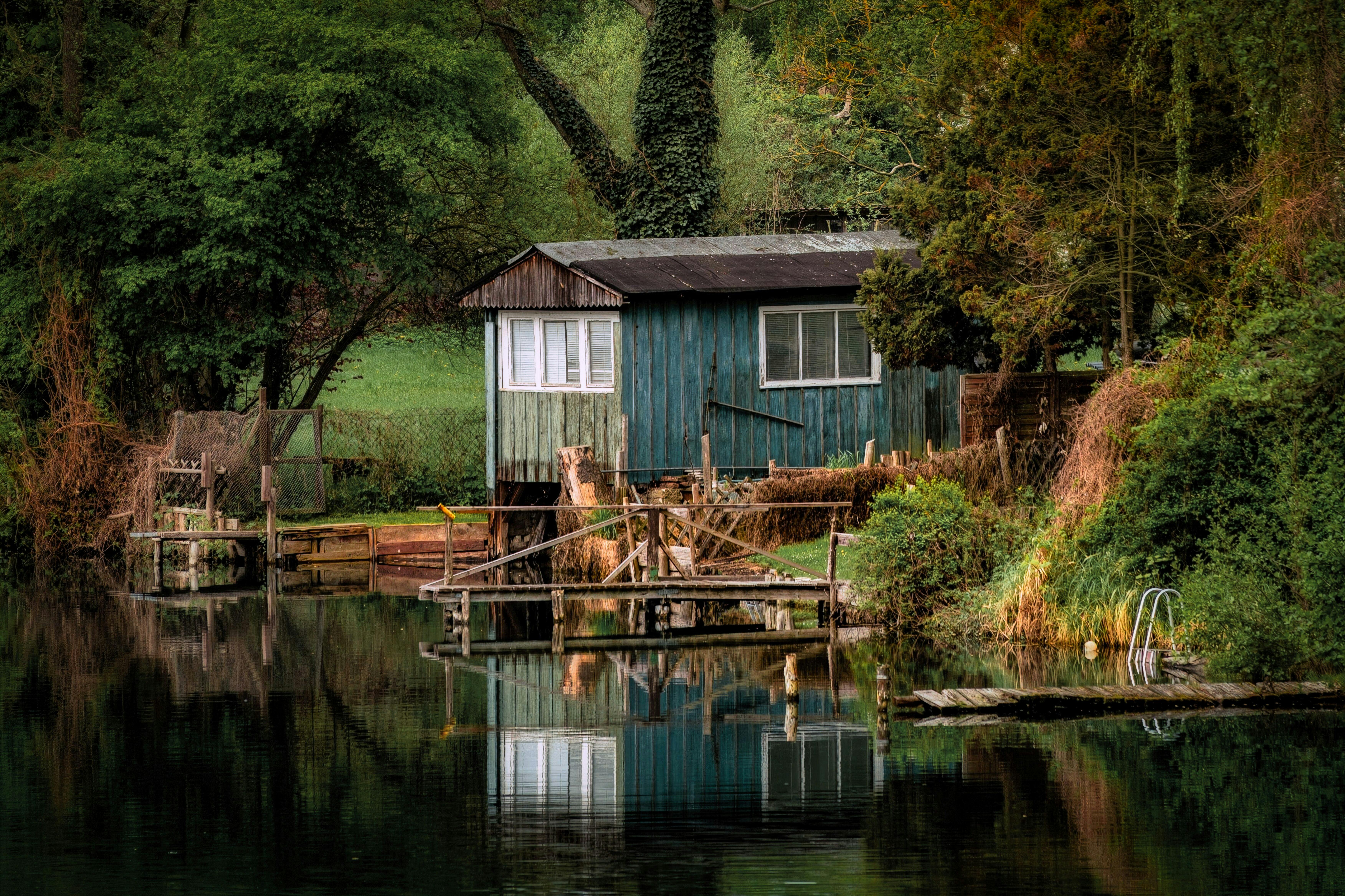 Деревянная избушка у спокойного озера в лесу