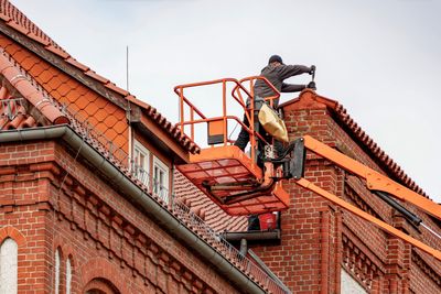 Technician performing roof waterproofing maintenance