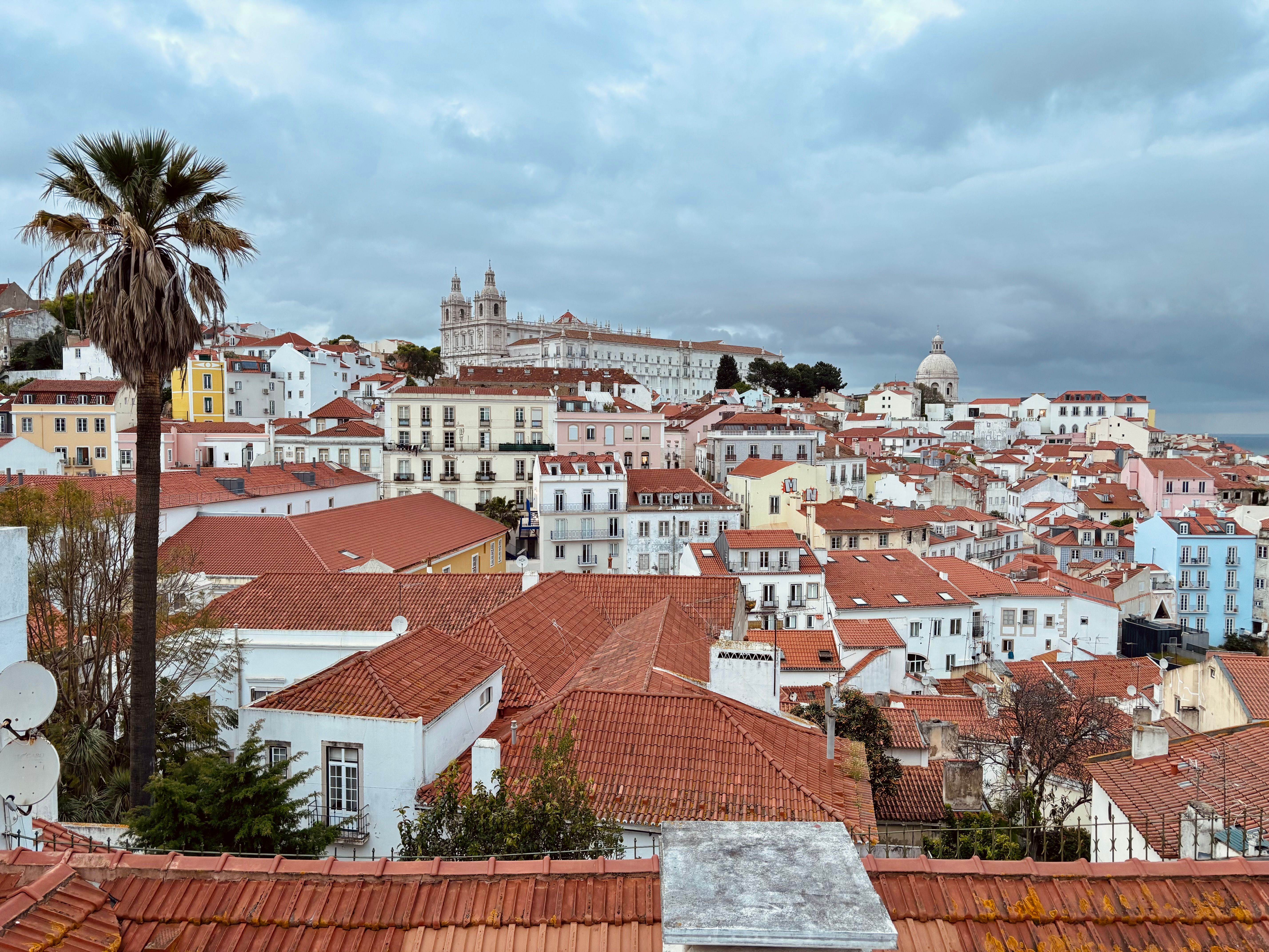 ฟรี ทิวทัศน์อันงดงามของย่าน Alfama ในลิสบอนซึ่งมีหลังคาบ้านสีแดงและสถาปัตยกรรมเก่าแก่ คลังภาพถ่าย