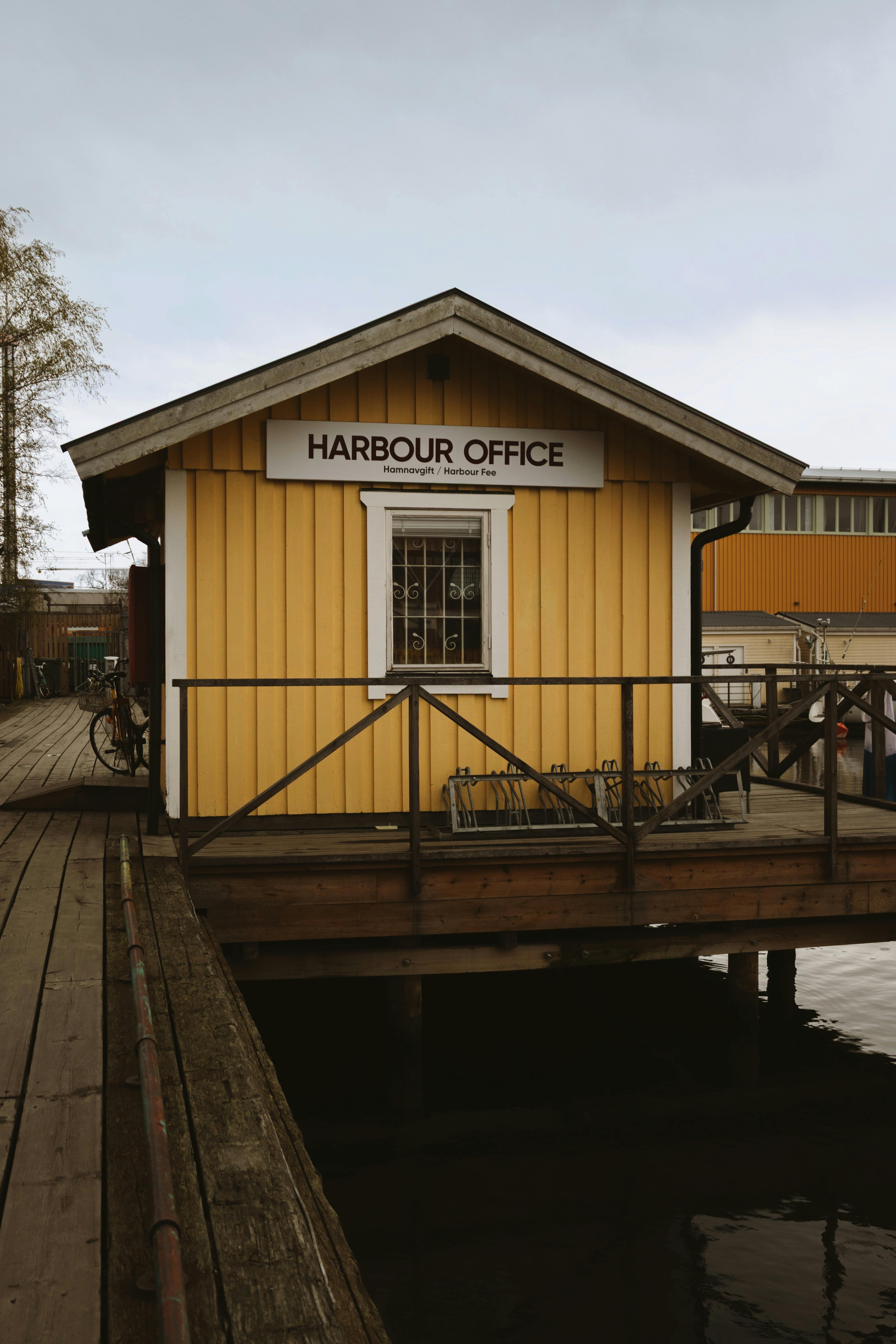 A picturesque yellow wooden harbour office by the calm Stockholm waterside.