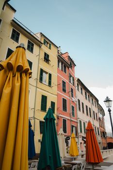 Vibrant umbrellas stand against historical European buildings creating a lively scene.