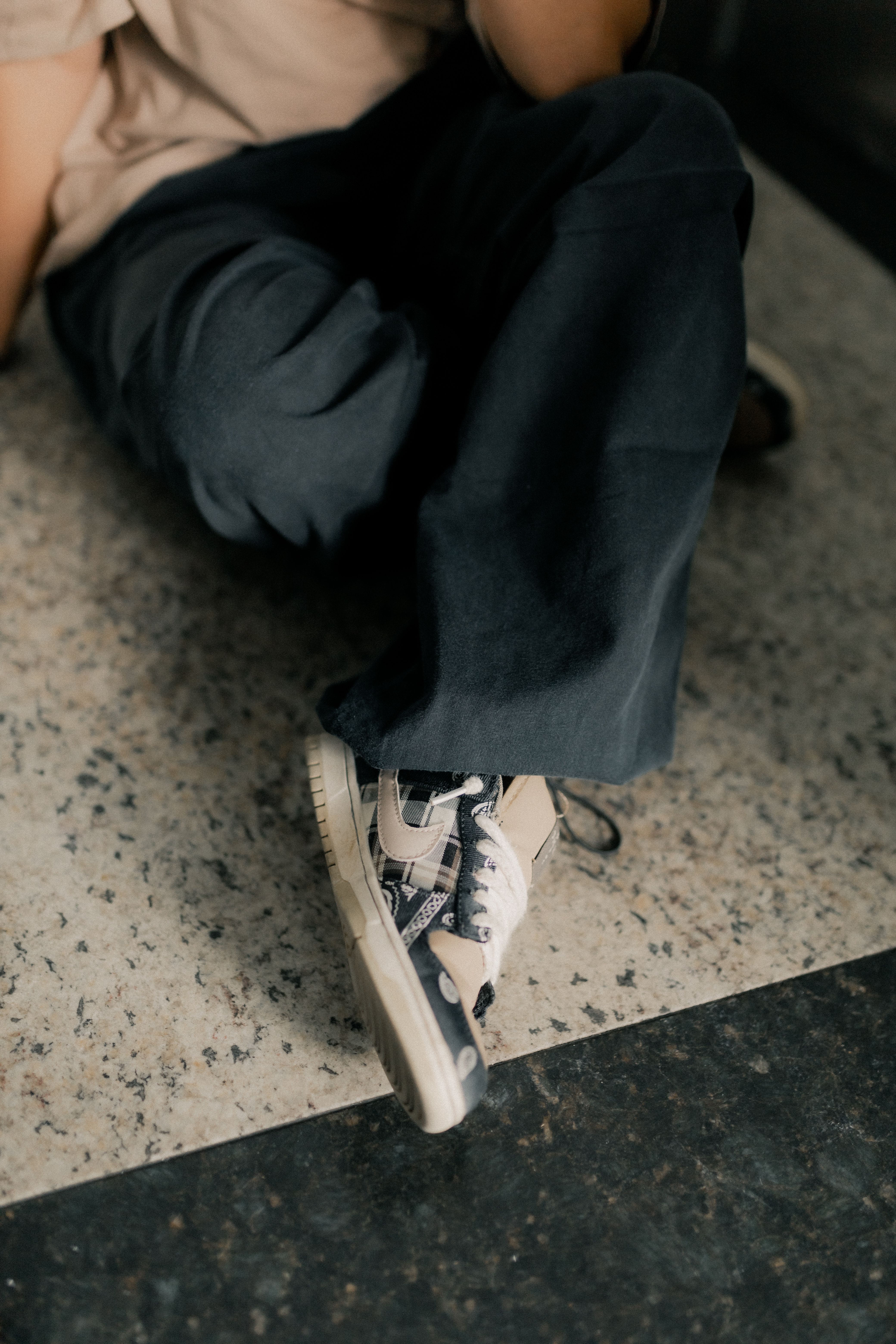 Close-up of stylish sneakers on a marble floor, showing casual fashion style.