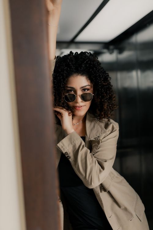 Free Fashionable woman in sunglasses poses confidently indoors, exuding style and sophistication. Stock Photo