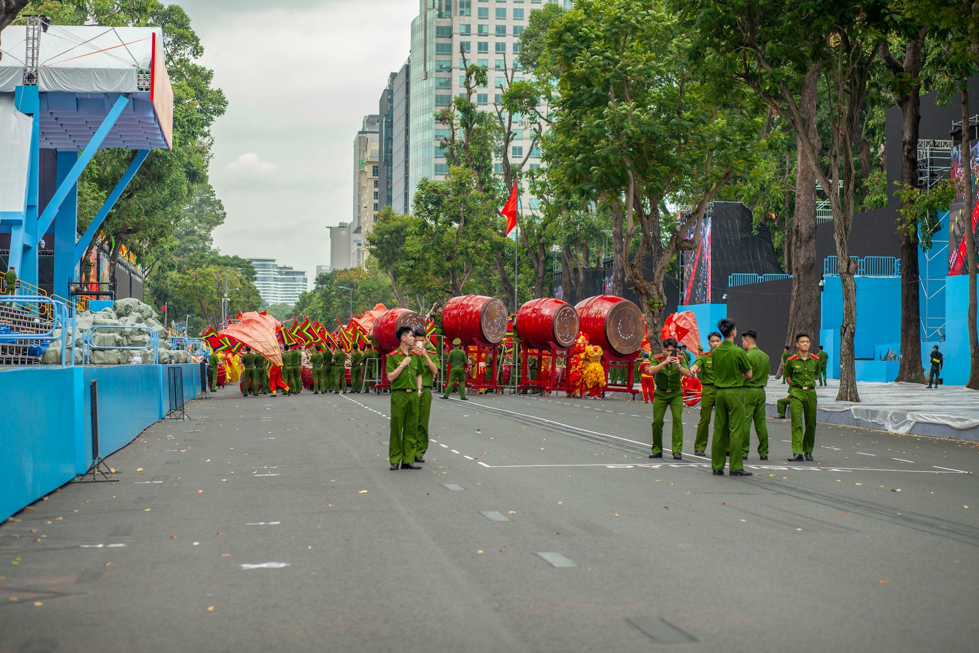 Vibrant street parade with red drums and performers in uniform on a city avenue.