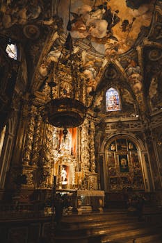 Intricately detailed Baroque church interior featuring a stunning frescoed ceiling and ornate altar.