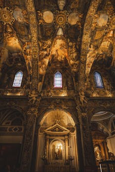 A breathtaking view of an intricately decorated church ceiling with stained glass windows.
