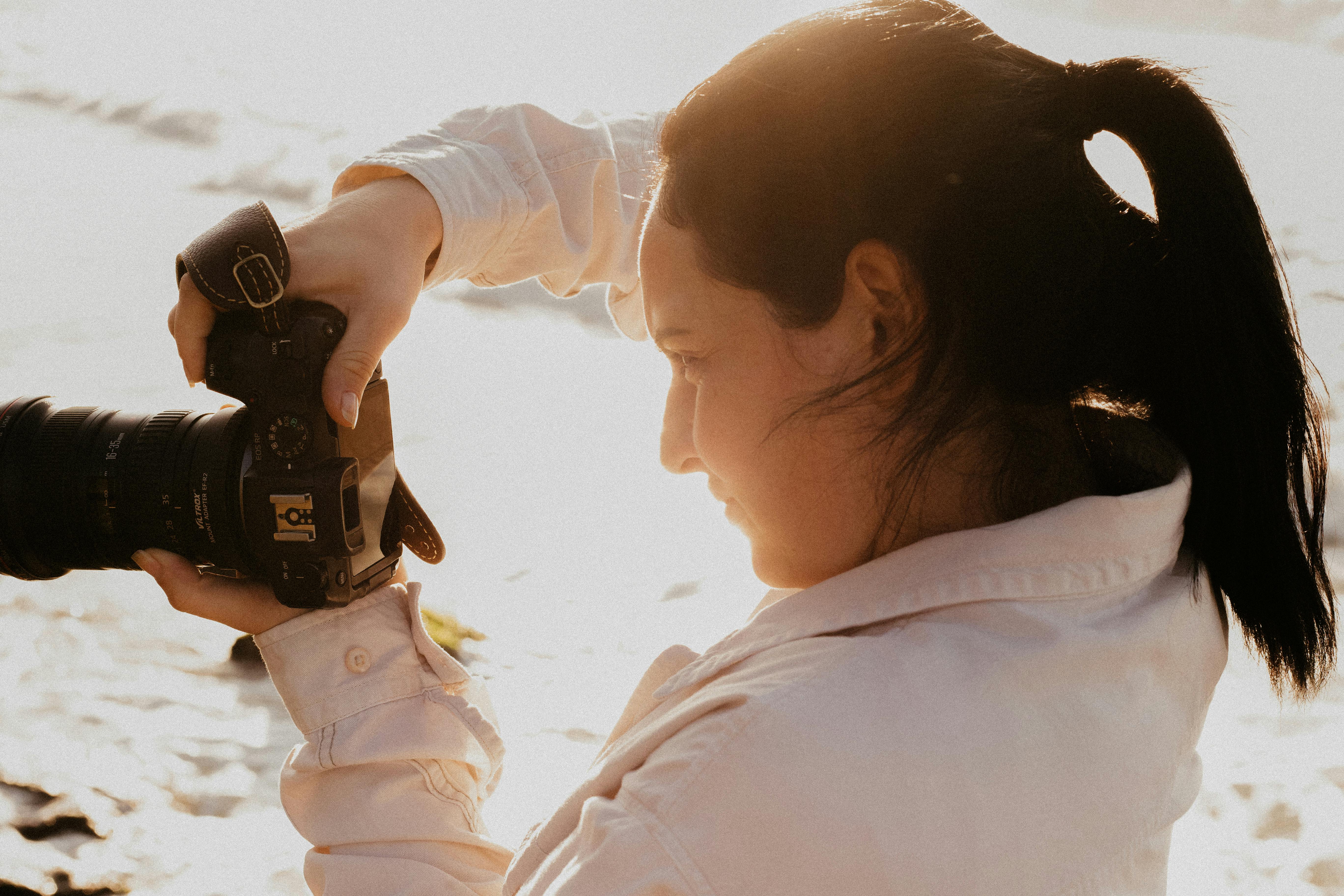 Free Female photographer shooting outdoors in warm sunlight. Stock Photo