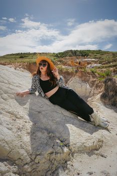 Fashionable woman in summer attire poses on rocky terrain in Calhan, Colorado.