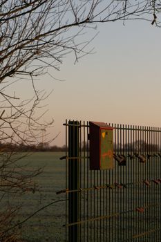 Scenic view of a fence with love padlocks and a mailbox at sunset in Achim, Germany.