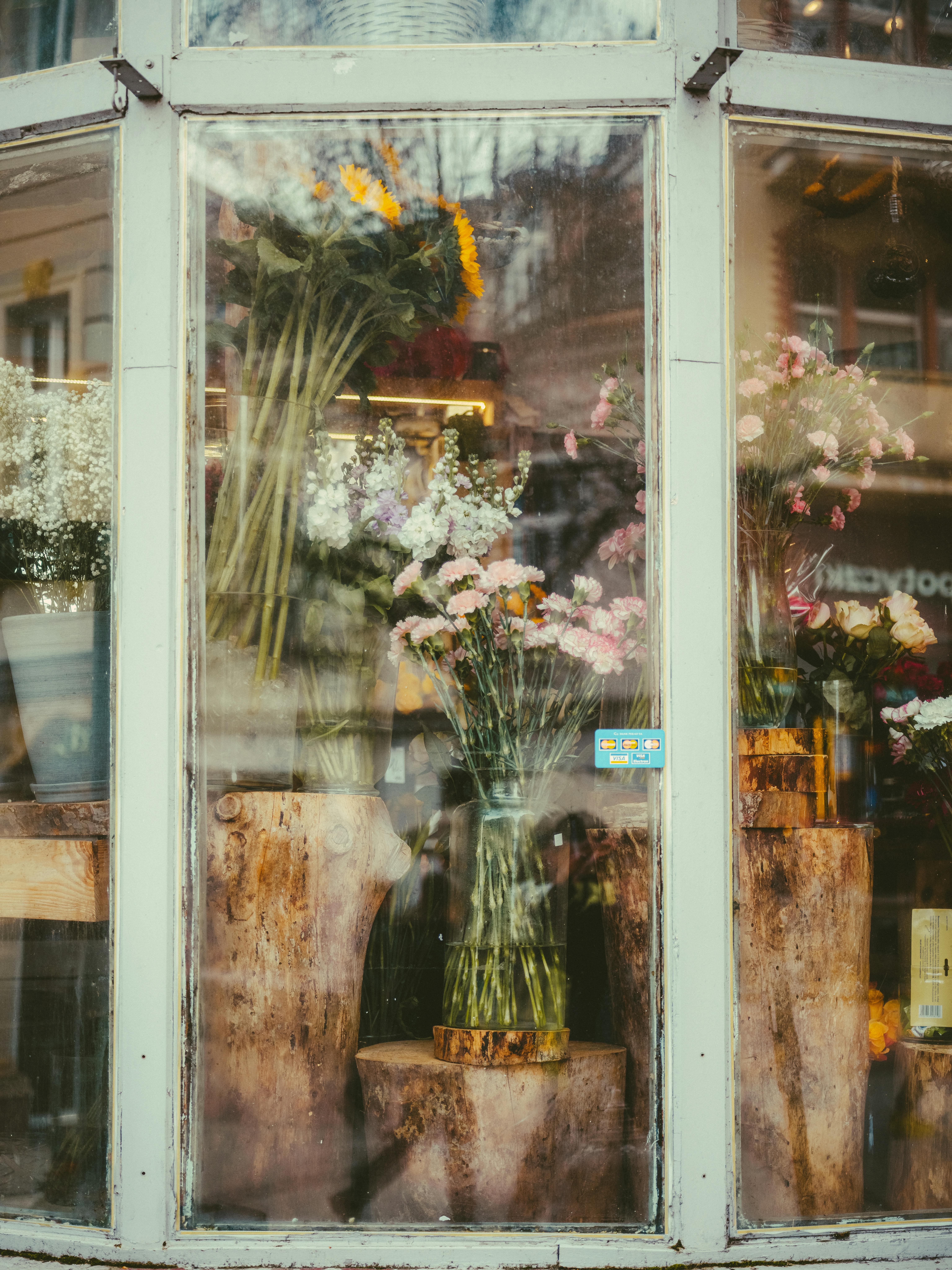Beautiful floral arrangement in rustic shop window, enhancing urban charm.