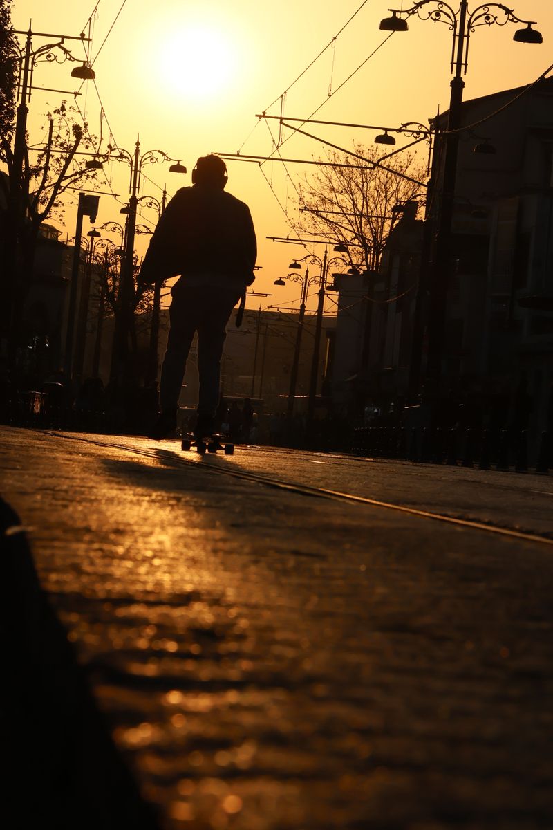 Skateboarder in silhouette on a street at sunrise — sehir gezgini on Pexels