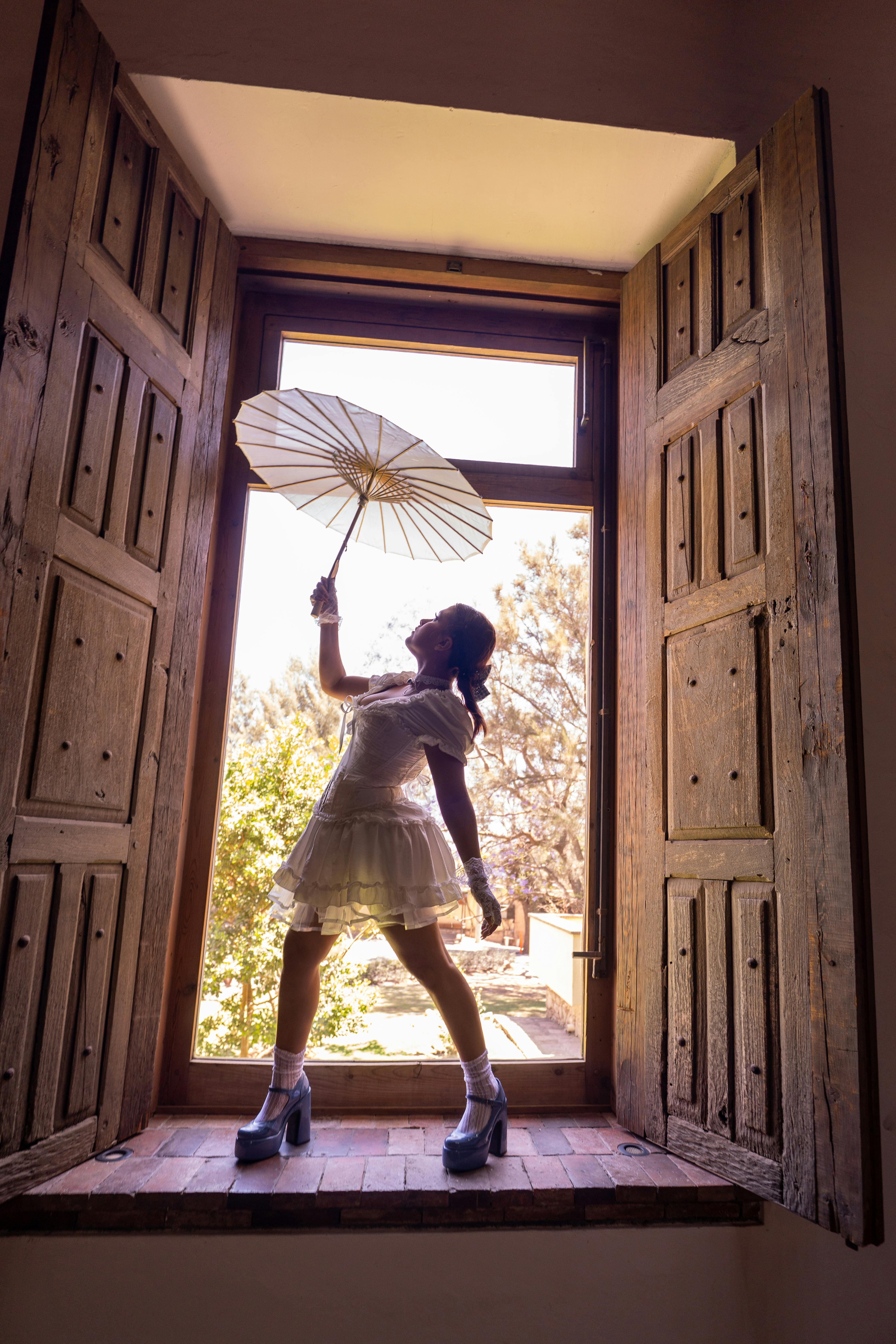 Zadarmo Silueta ženy držiacej dáždnik v slnečnom okne v Leone v Mexiku. Fotka z fotobanky