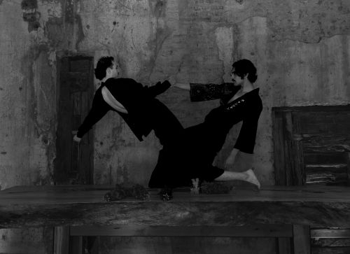 Free Two dancers in dramatic pose against rustic backdrop in black and white. Stock Photo