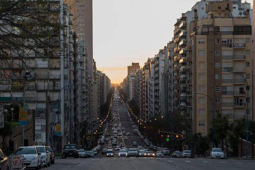 Free Long avenue lined with tall buildings under a warm sunset in Mar del Plata, Argentina. Stock Photo