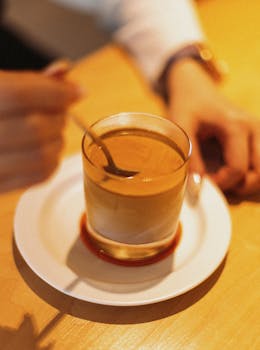 Close-up of a latte being stirred in a Tokyo cafe, capturing the essence of Japanese coffee culture.