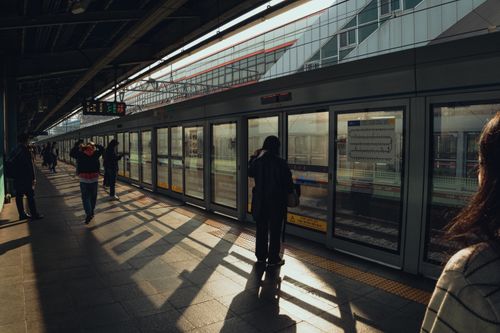 Free Seoul subway station scene with commuters in warm afternoon light, capturing urban life. Stock Photo