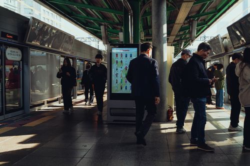 Free Commuters at a bustling Seoul subway station platform during the day. Stock Photo
