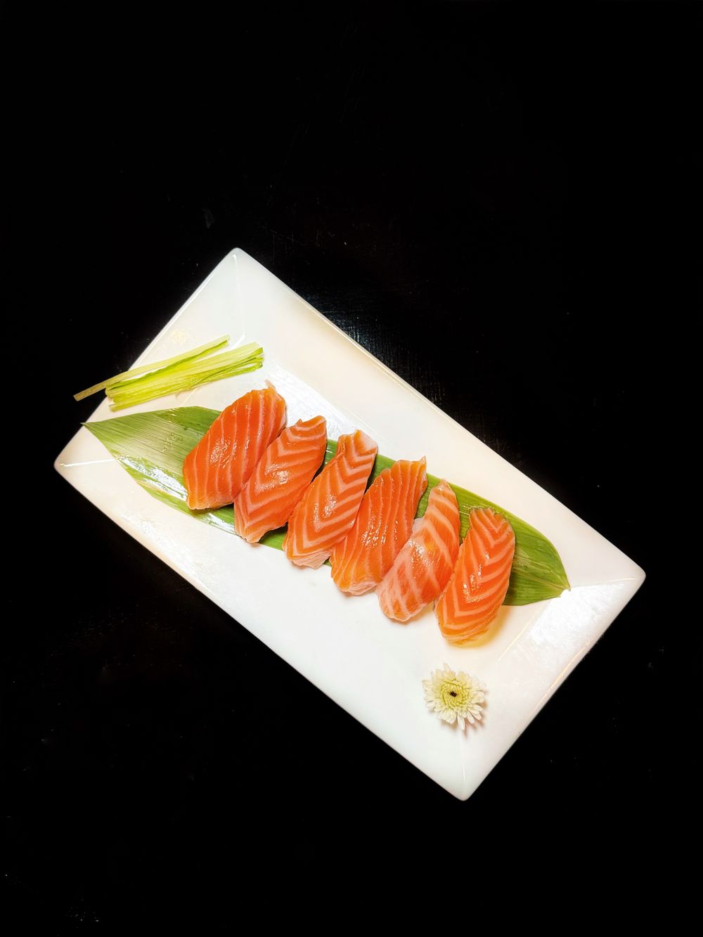 Láminas de sashimi de salmón en una fuente; fotografía referencial