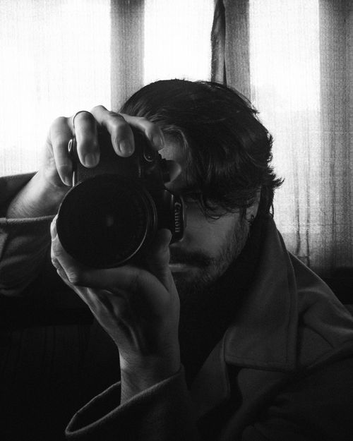 Free Monochrome image of a photographer focusing intensely behind the camera. Stock Photo
