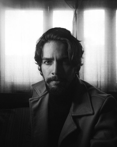 Free Thoughtful and introspective black and white portrait of a man in a dimly lit room. Stock Photo