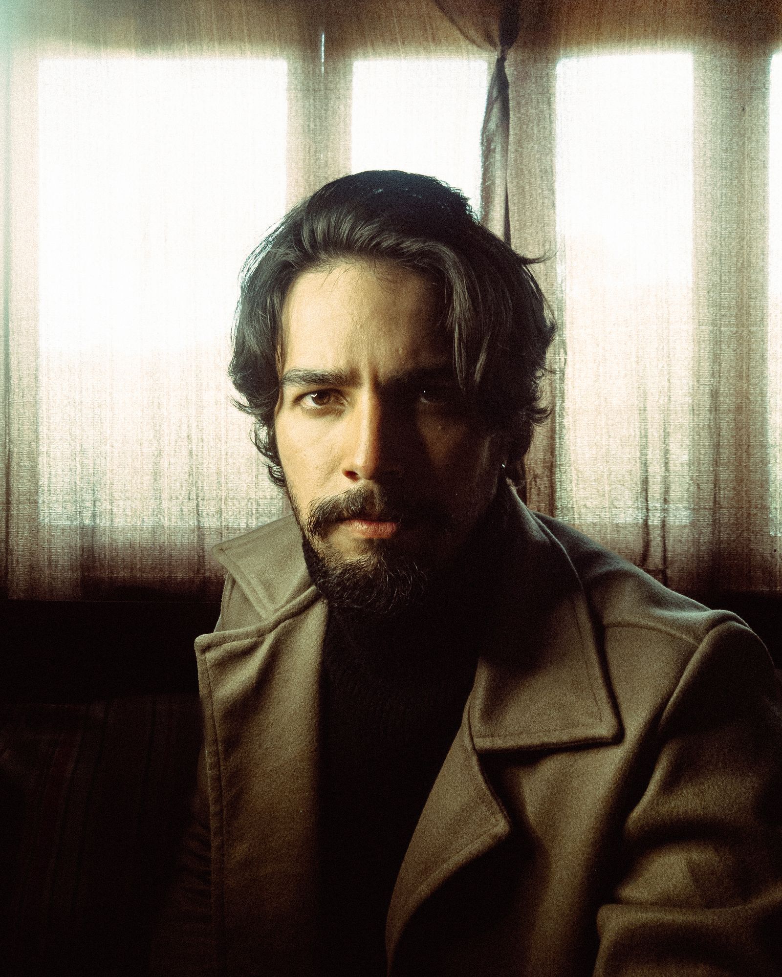 Contemplative portrait of a man lit by soft natural window light