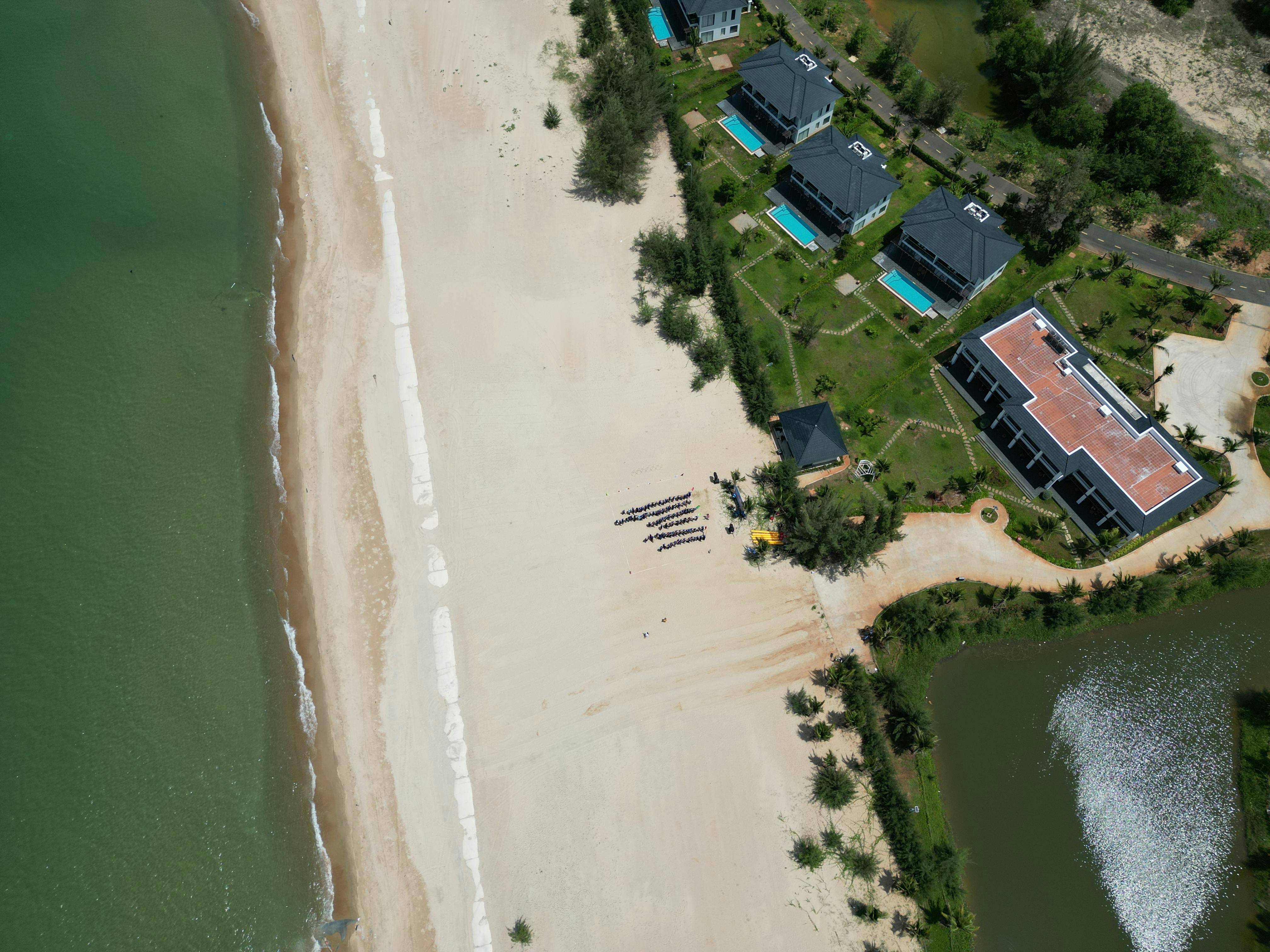 An aerial view of a luxury beachfront resort in Hồ Tràm, showcasing turquoise waters and sandy beaches.