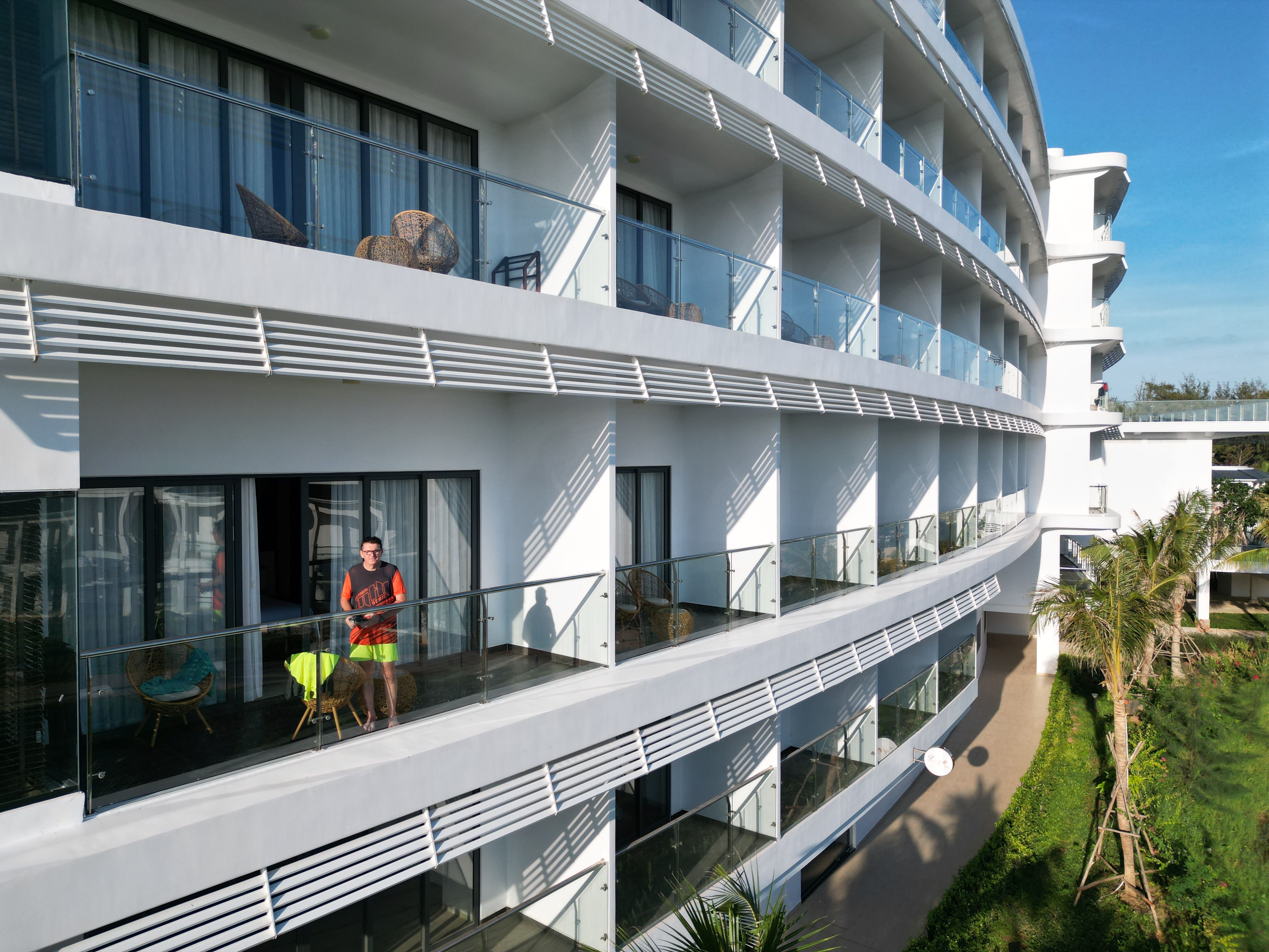 Aerial view of a modern resort in Hồ Tràm, Vietnam with a person on the balcony.