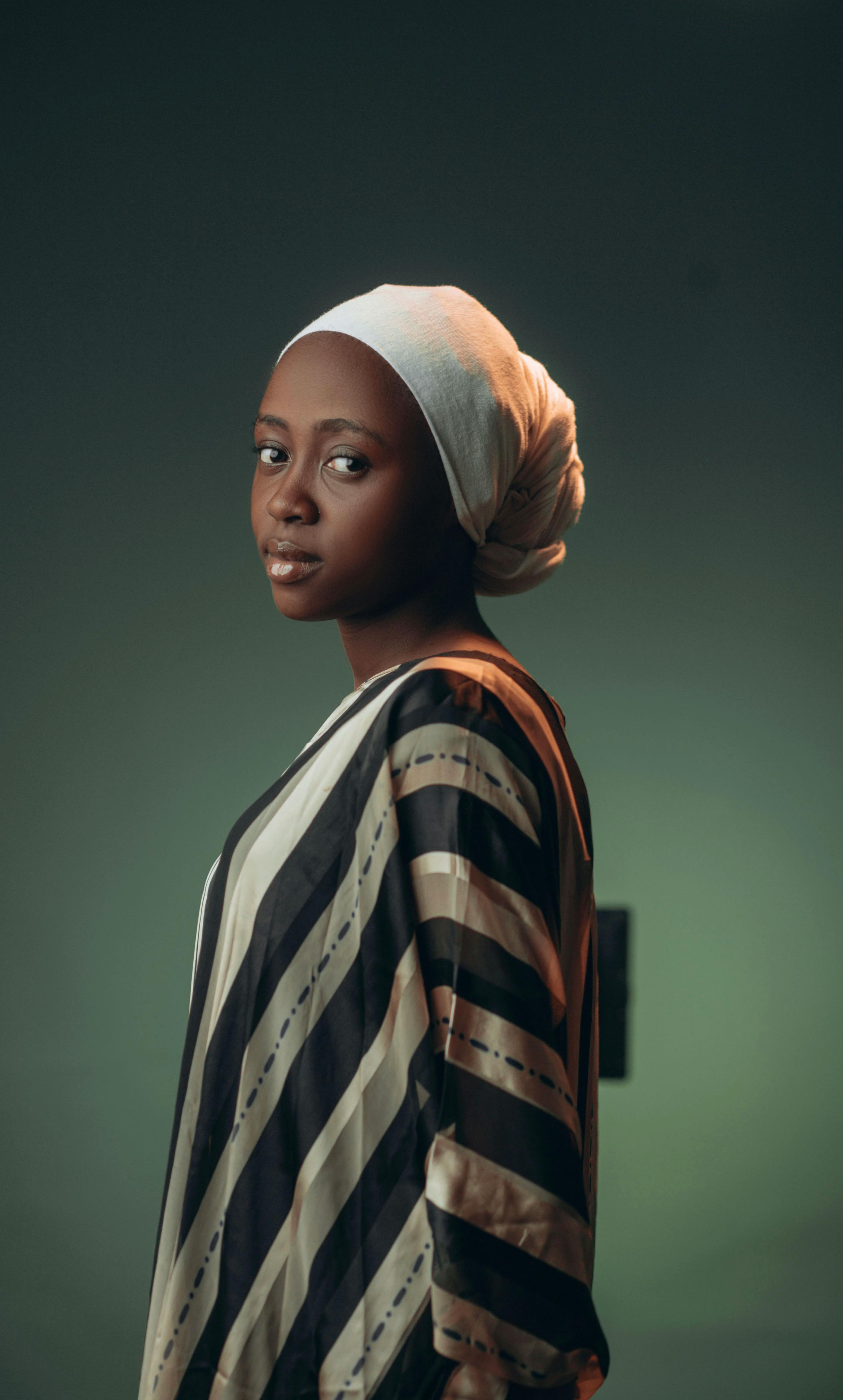 Portrait of an elegant woman in traditional attire with a serene expression on a neutral background.