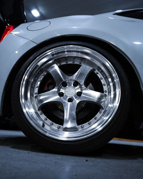 Free Detailed close-up of a polished, custom car wheel with metallic finish under bright lighting. Stock Photo