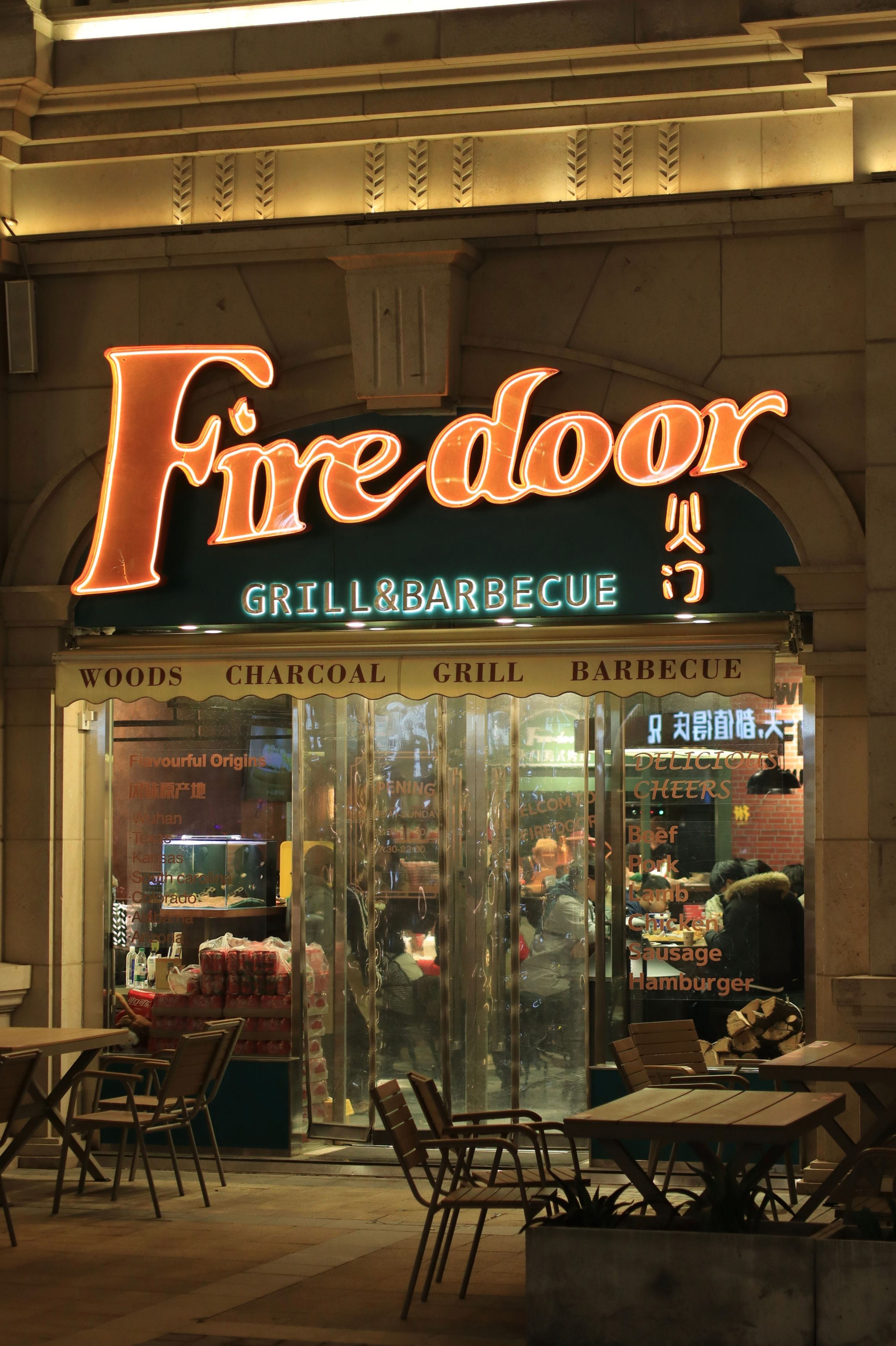 Firedoor Grill & Barbecue entrance illuminated at night in urban setting.