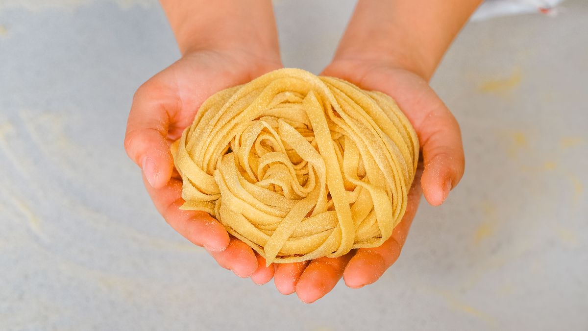 Maini tinand un cuib de tagliolini proaspete