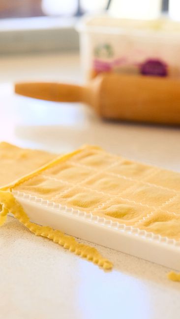 Fotomural Primer plano de ravioles caseros que se preparan con una tabla de pasta y un rodillo.