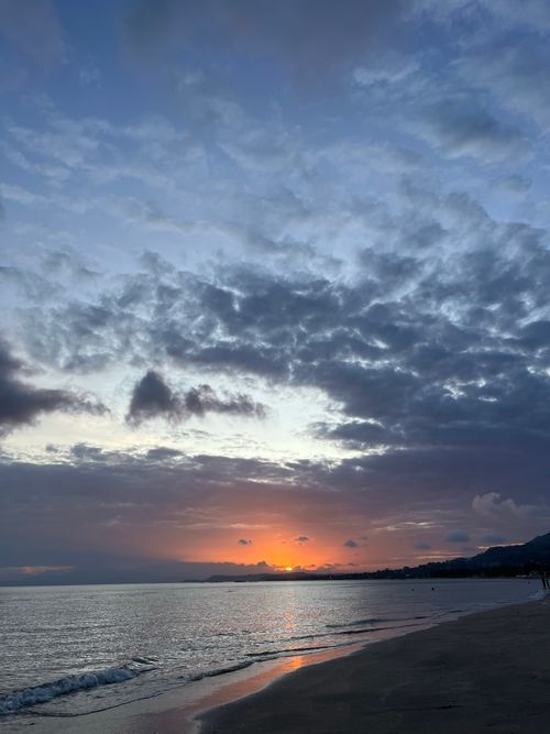 Free Tranquil beach scene showcasing a vibrant sunset and a serene atmosphere. Stock Photo